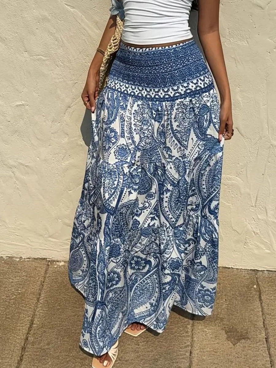 Person wearing a blue and white patterned skirt against a beige wall.