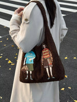Brown textured bag with embroidered characters held by a person on a black and white striped background.