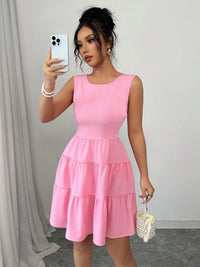 Woman wearing a pink dress taking a mirror selfie.
