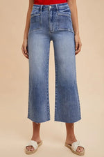 Person wearing blue wide-leg jeans on a beige background