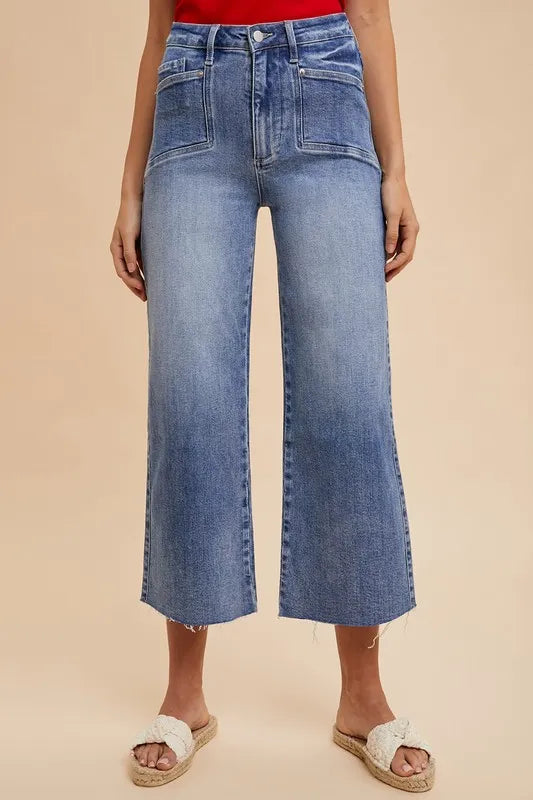 Person wearing blue wide-leg jeans on a beige background