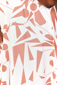 Close-up of a garment with abstract geometric pattern in pink and white.