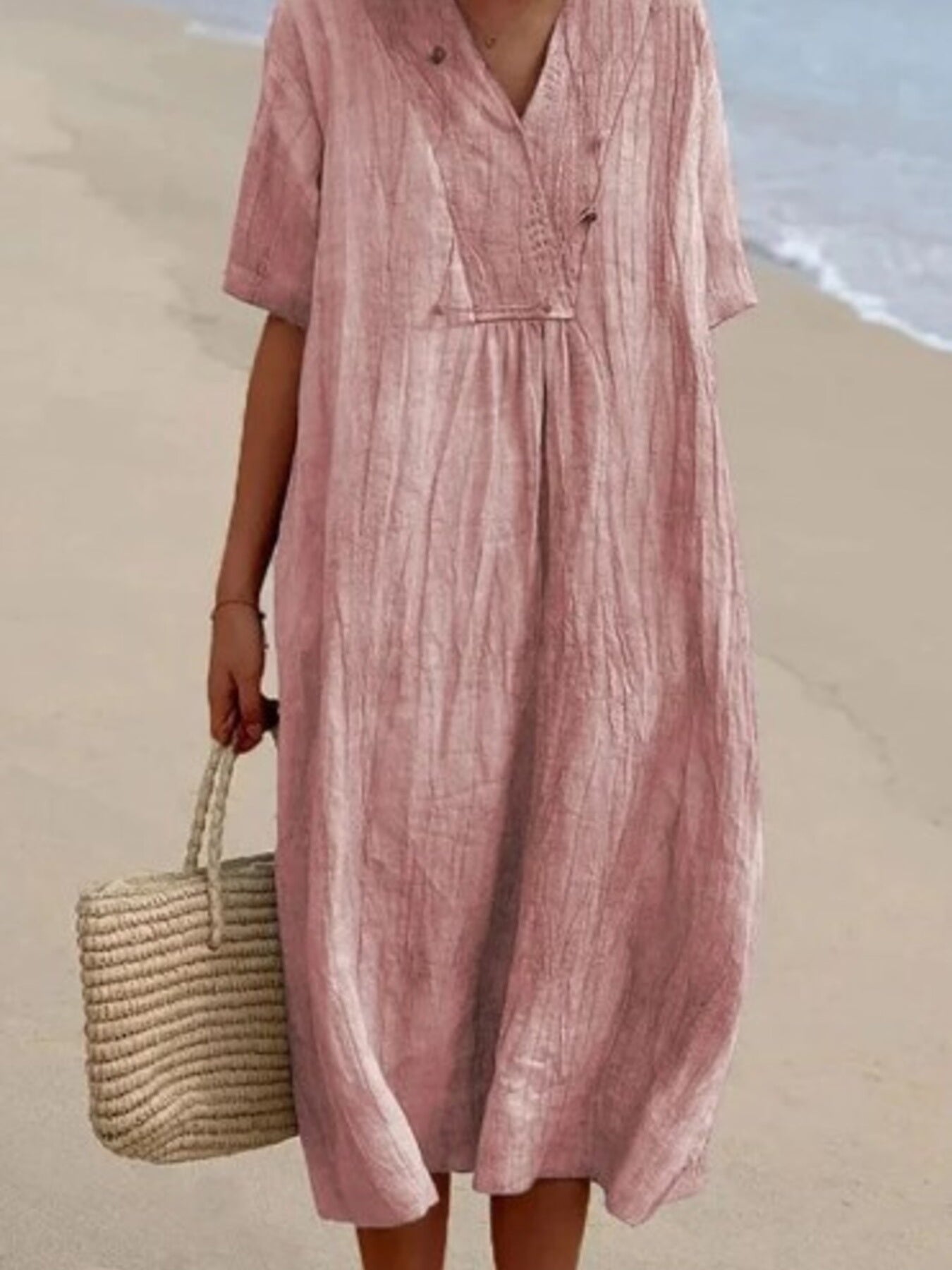 Person wearing a pink dress on a beach