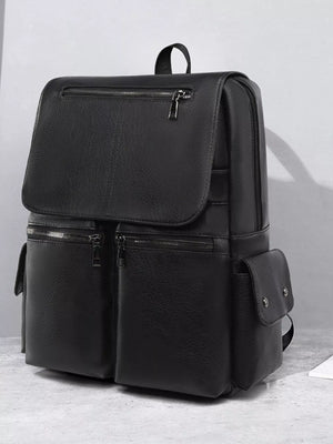 Black backpack on a light gray surface with a neutral background