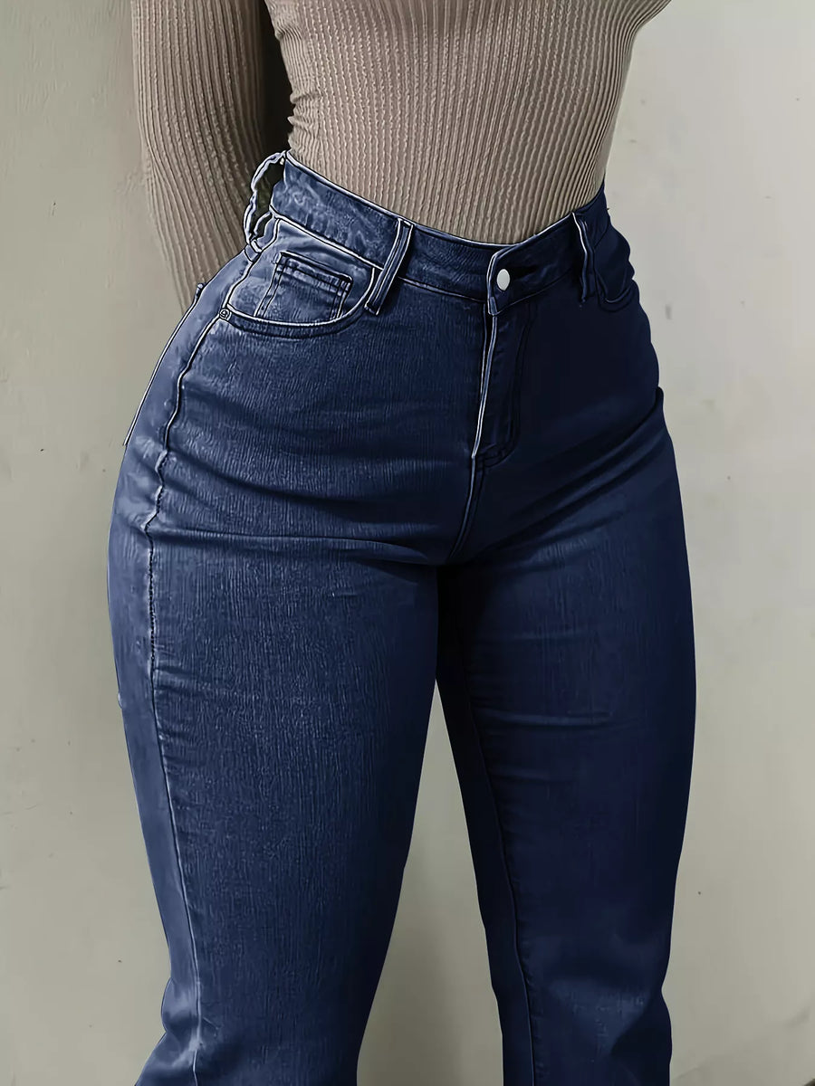 Person wearing blue jeans and a beige ribbed top against a plain background
