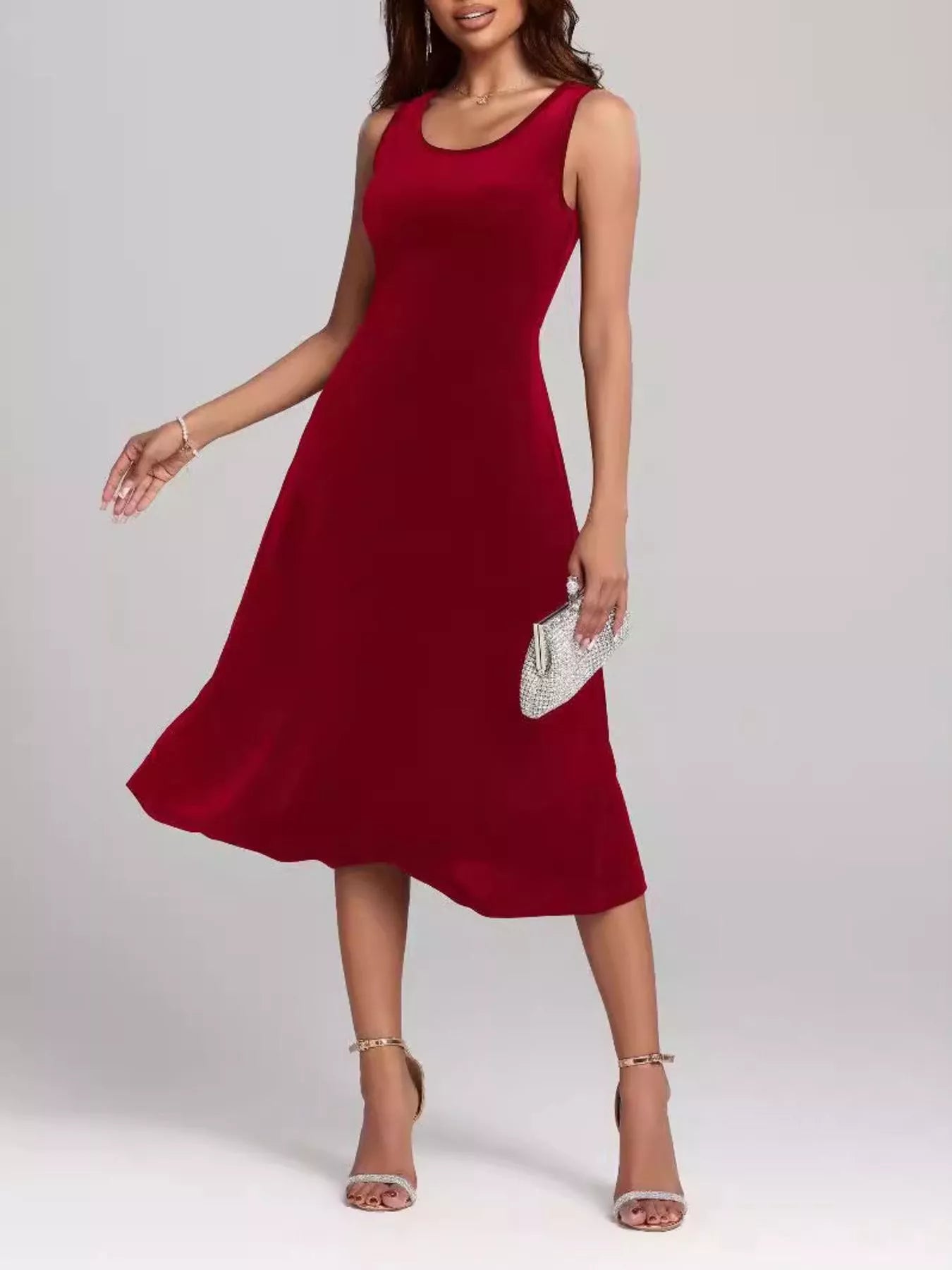 Woman wearing a red sleeveless dress on a plain background