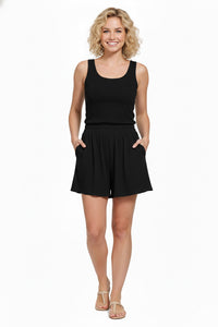 Woman wearing a black sleeveless top and black skirt on a white background