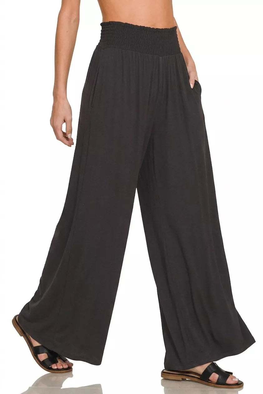 Black wide-leg pants worn by a person on a white background