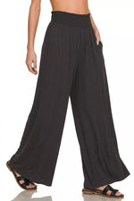 Black wide-leg pants worn by a person on a white background