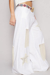 White saree with colorful embroidery on a plain background