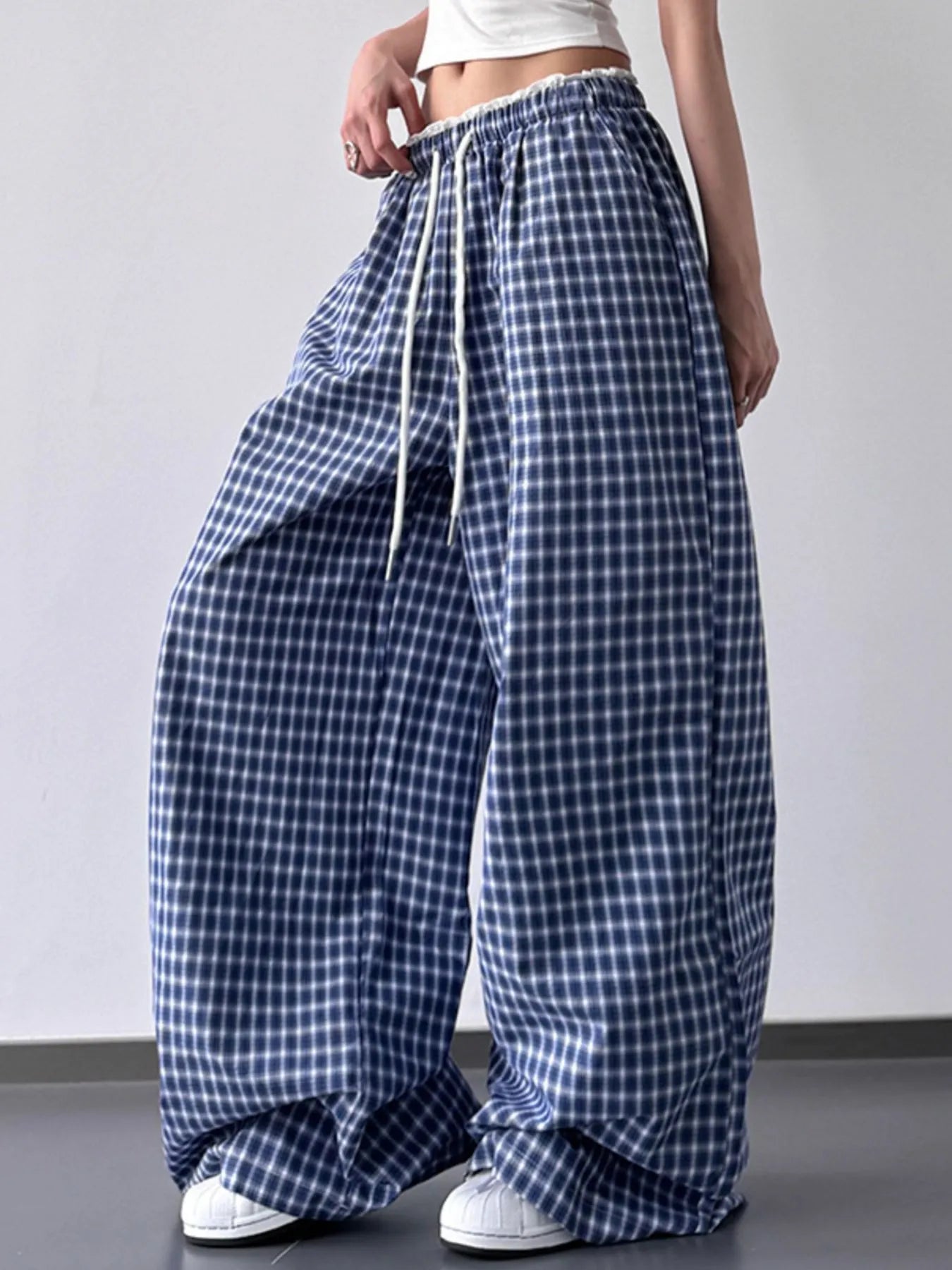 Blue and white checkered wide-leg pants worn by a person on a plain background