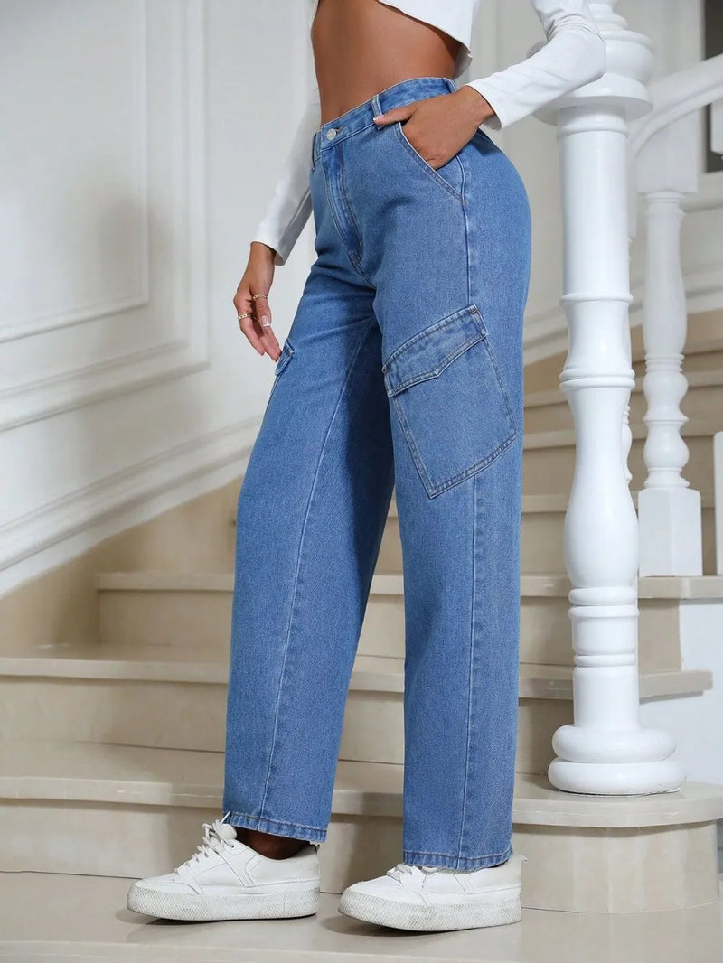 Person wearing blue jeans and white sneakers standing on a staircase.
