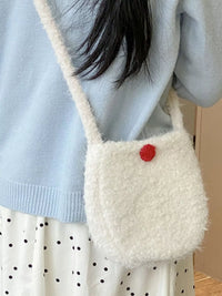 Person wearing a fluffy white bag with a red pom-pom, light blue sweater, and polka dot skirt.