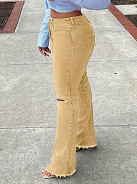 Person wearing beige flared jeans on a sidewalk