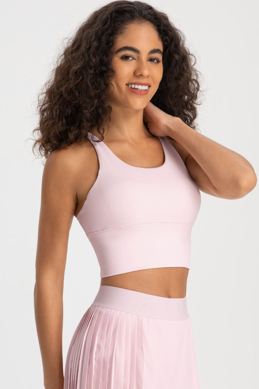 Woman wearing a pink athletic outfit on a white background