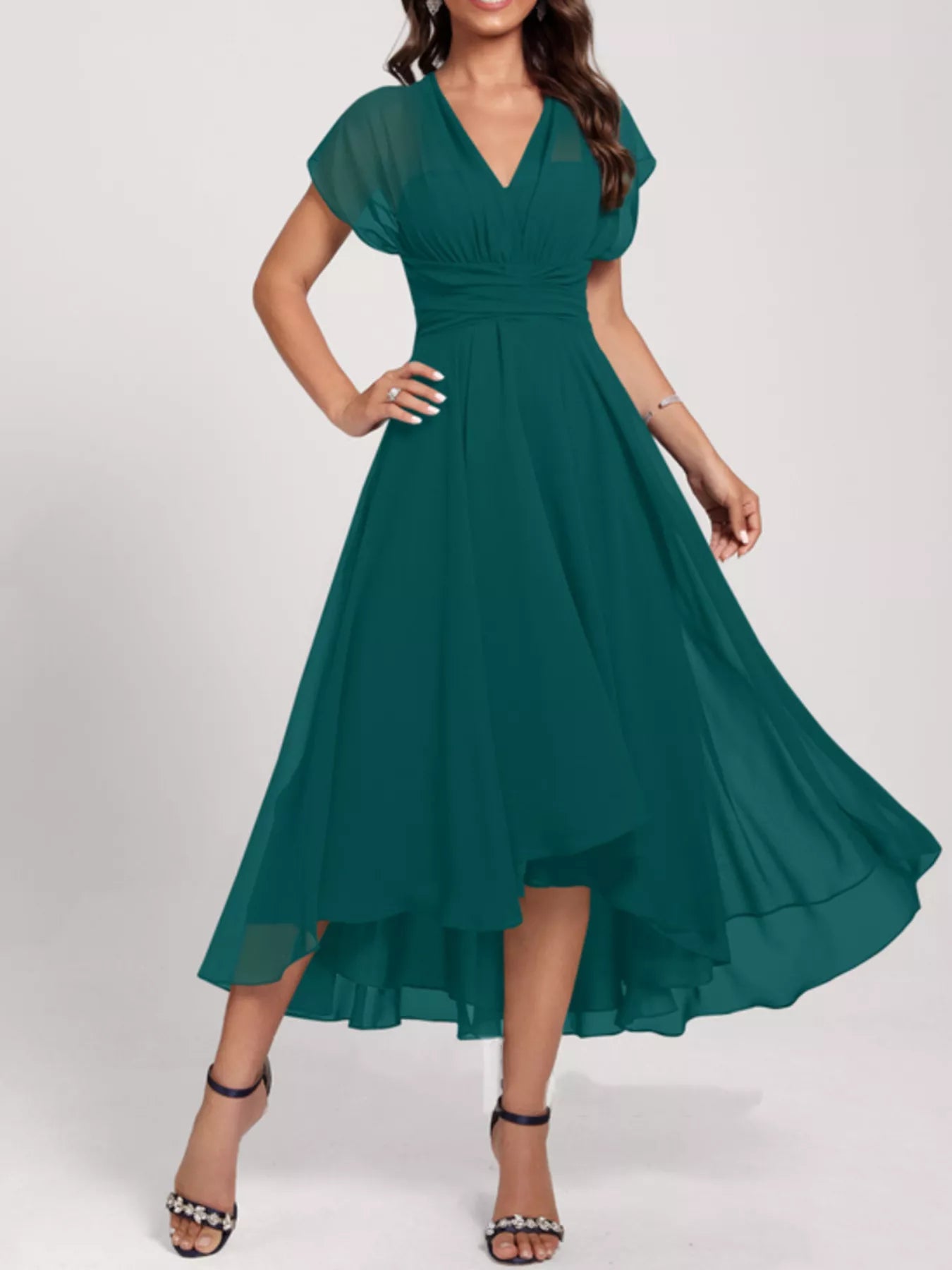 Woman wearing a teal dress on a white background
