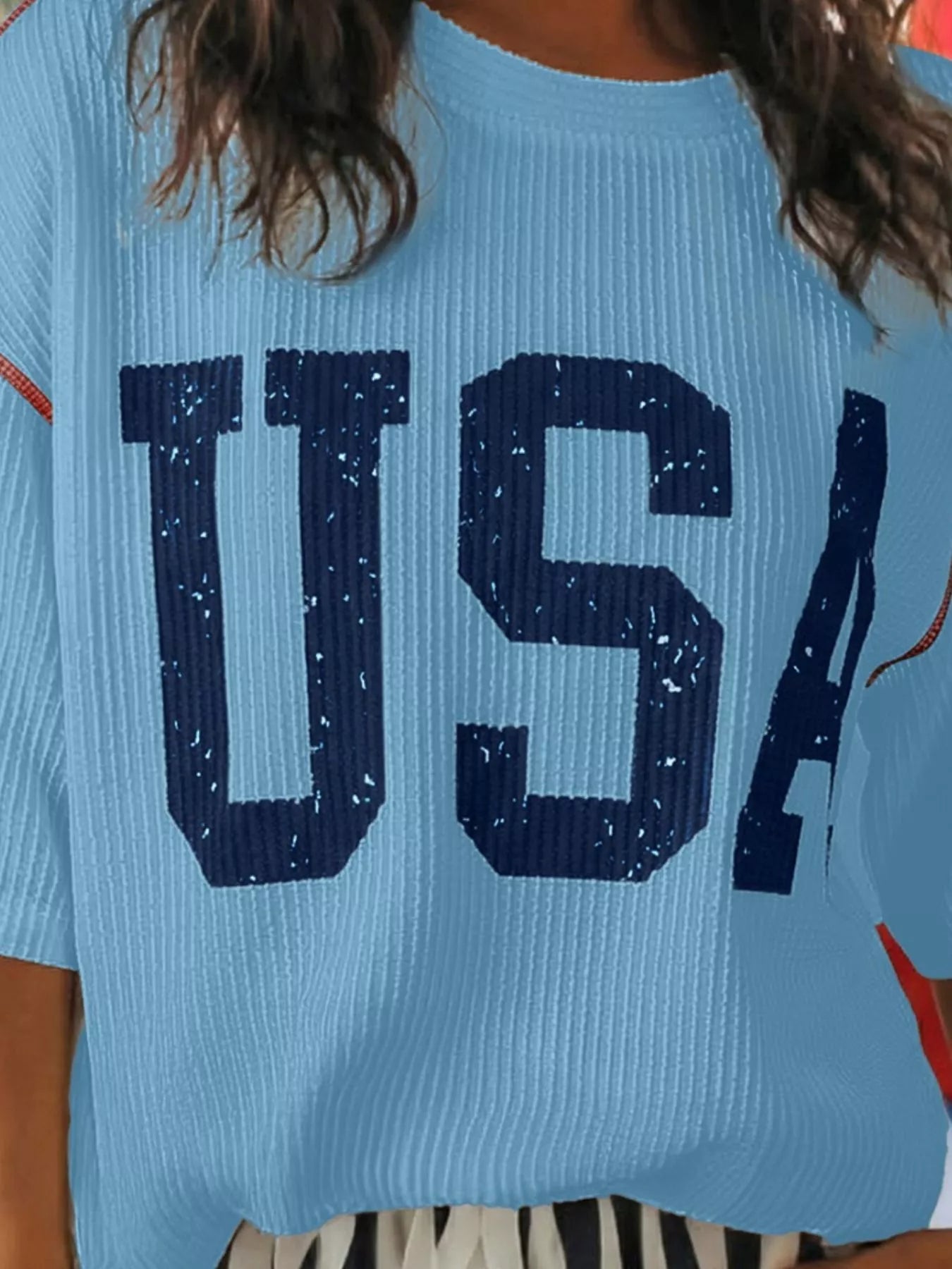 Light blue sweater with 'USA' text worn by a person
