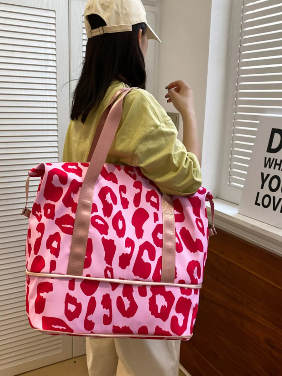 Person holding a pink backpack with red leopard print in a room.