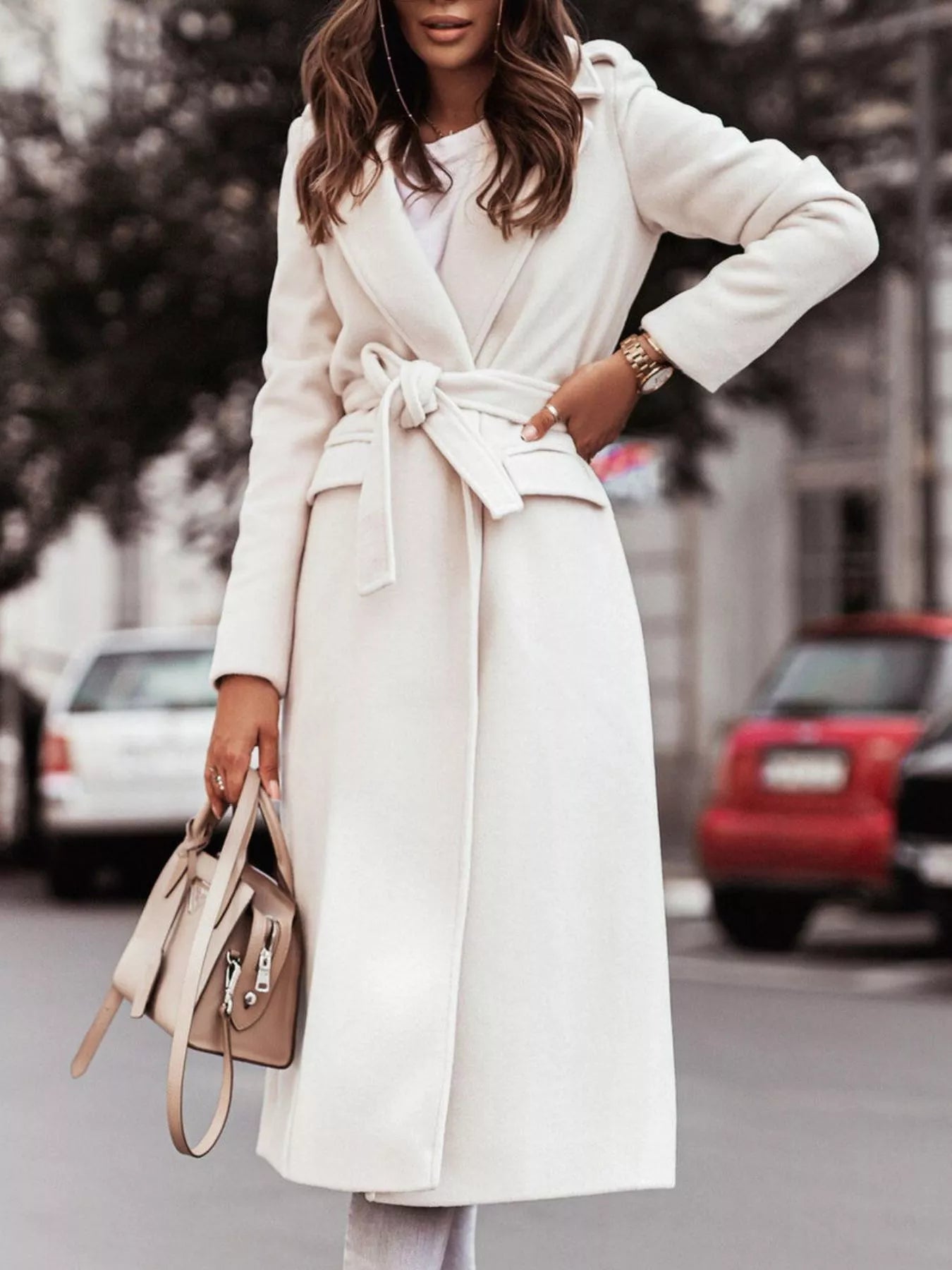 Person wearing a white coat with a blurred street background