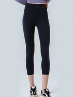 Person wearing black leggings on a white background