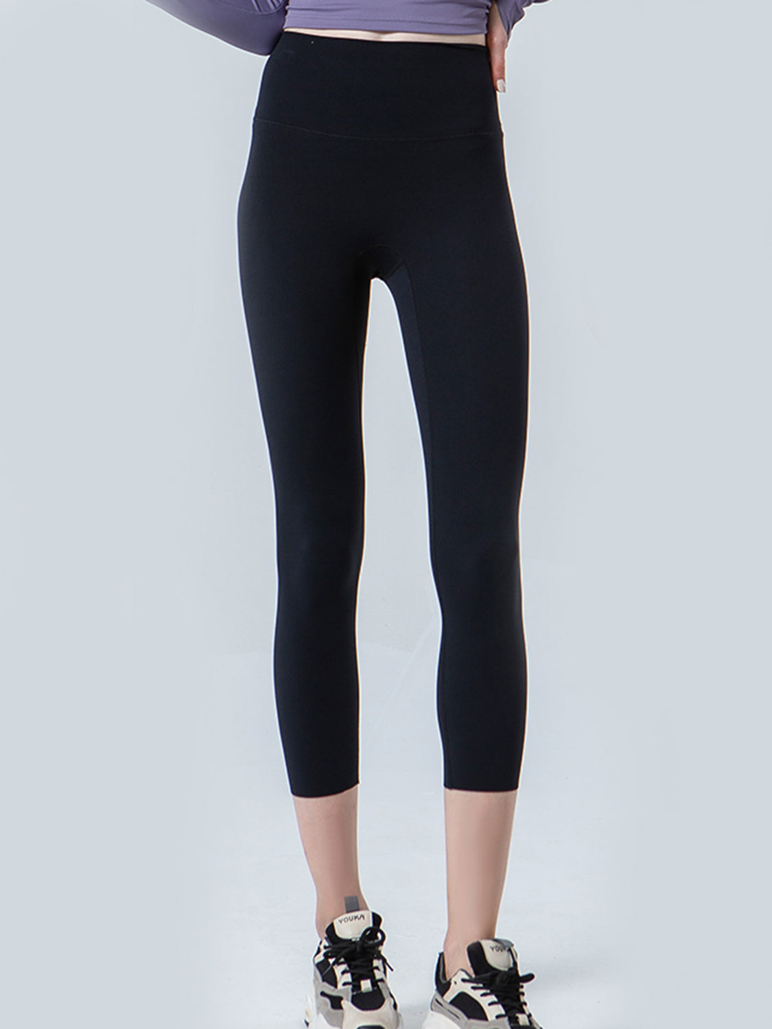 Person wearing black leggings on a white background