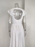 White dress with cut-out back on a mannequin against a plain background