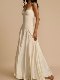 Woman wearing a long white dress against a beige background