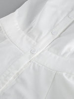 Close-up of a white shirt with buttons on a gray background