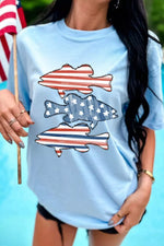 Woman wearing a light blue t-shirt with fish and American flag design, holding an American flag.