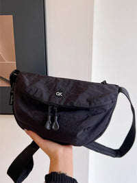 Black bag held by a person with a neutral background