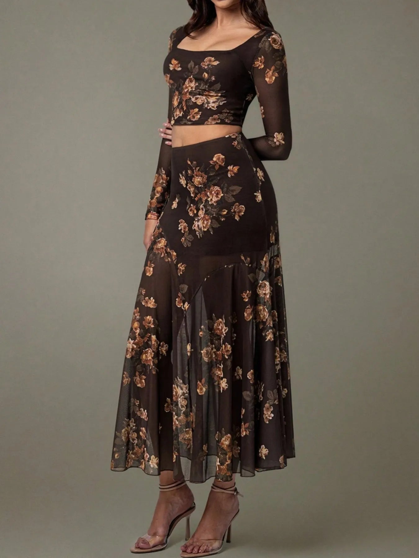 Woman wearing a black floral two-piece outfit on a gray background