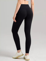 Person wearing black leggings on a gray background