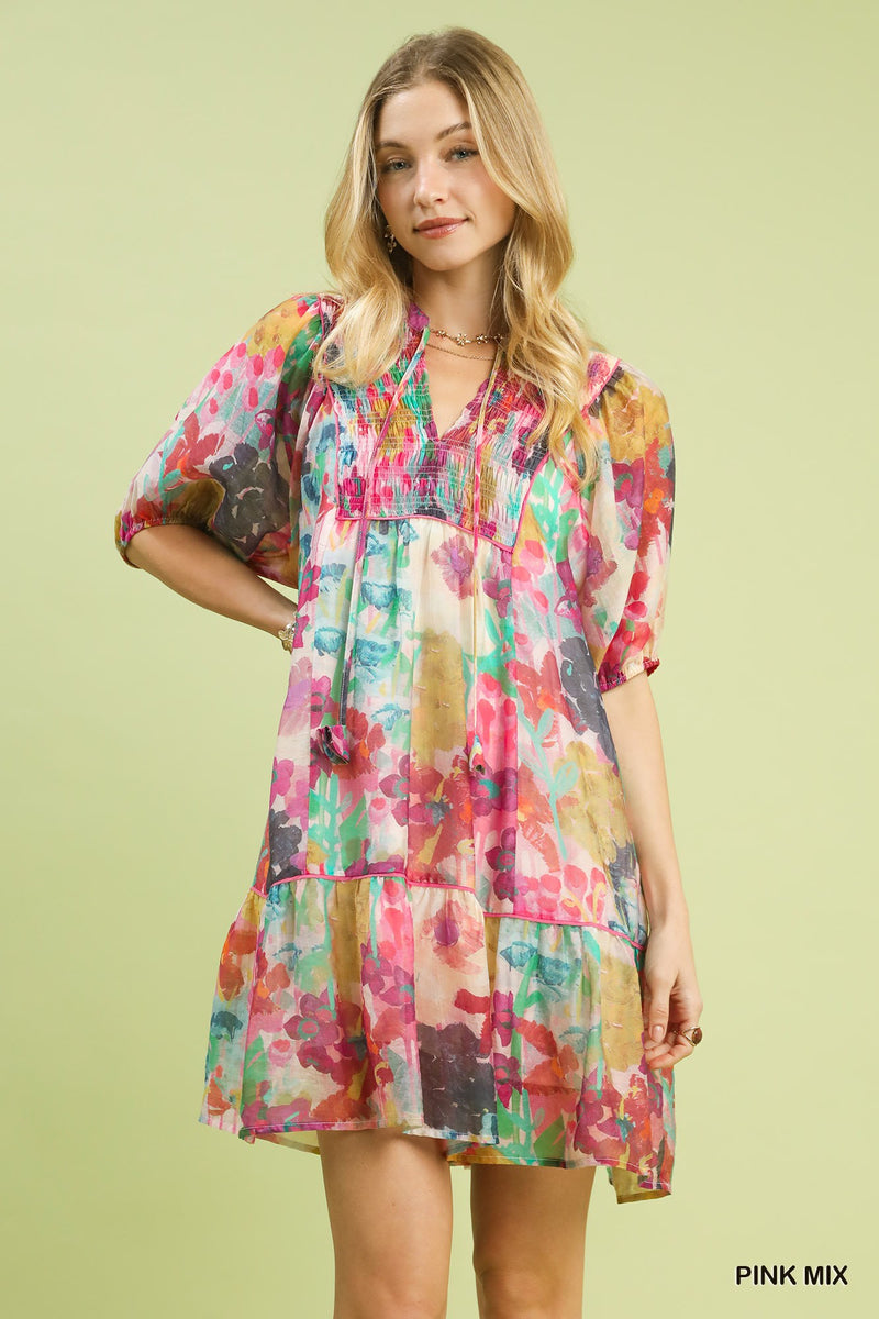 Woman wearing a colorful floral dress on a light green background