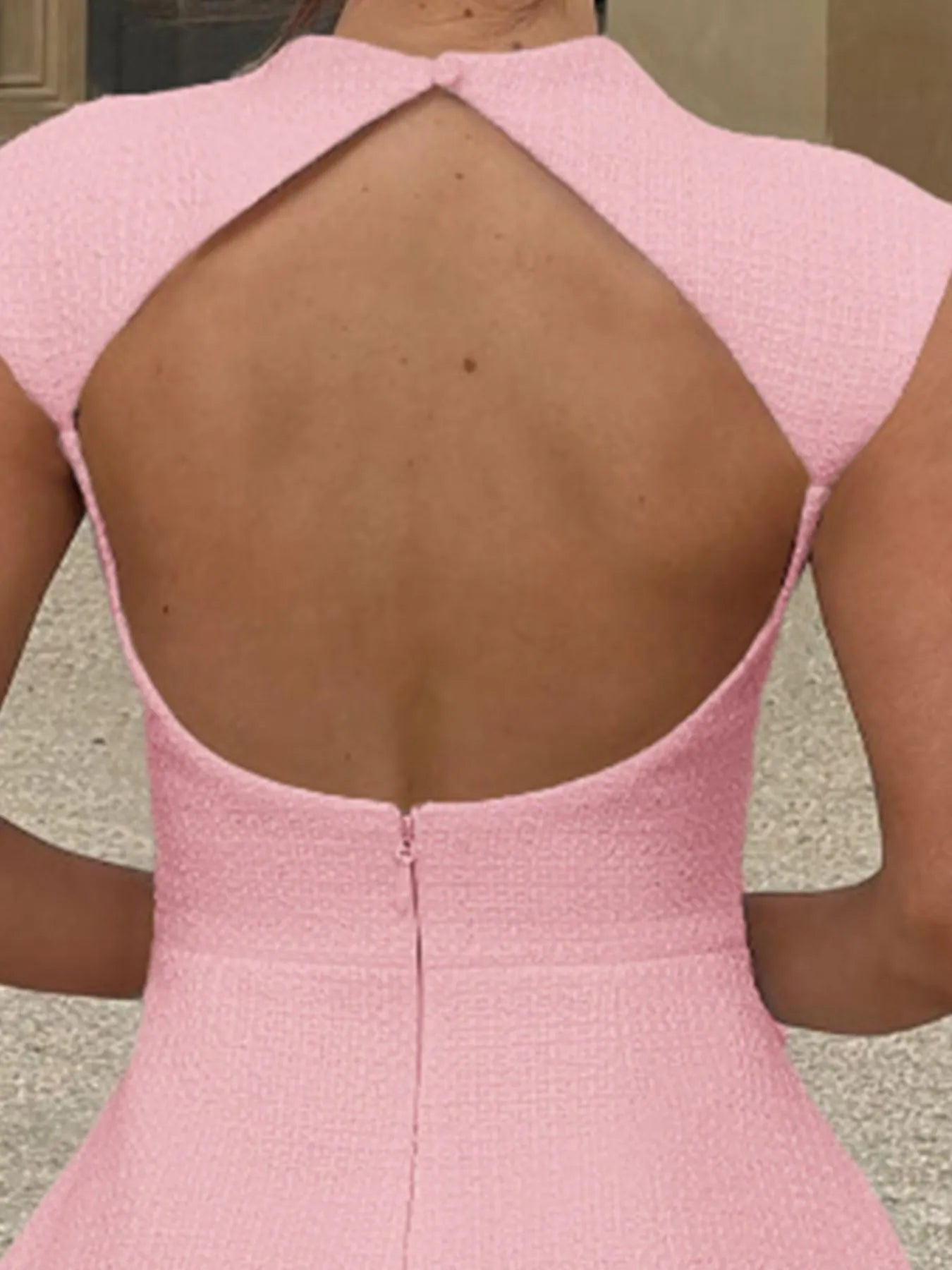 Close-up of a pink dress with an open back.