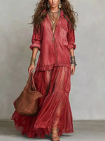 Woman wearing a red bohemian outfit with a brown bag against a neutral background