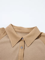 Close-up of a beige collared shirt with a plain background