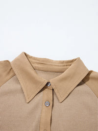 Close-up of a beige collared shirt with a plain background