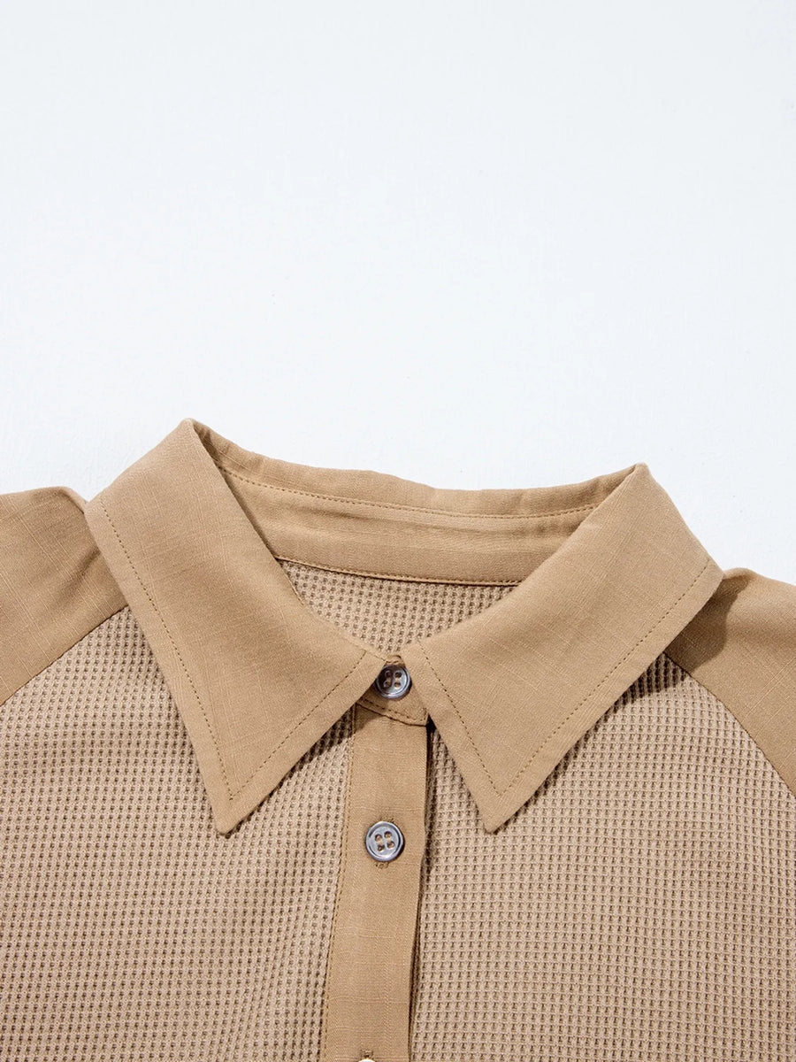 Close-up of a beige collared shirt with a plain background