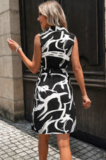 Woman wearing a black and white patterned dress standing on a street.