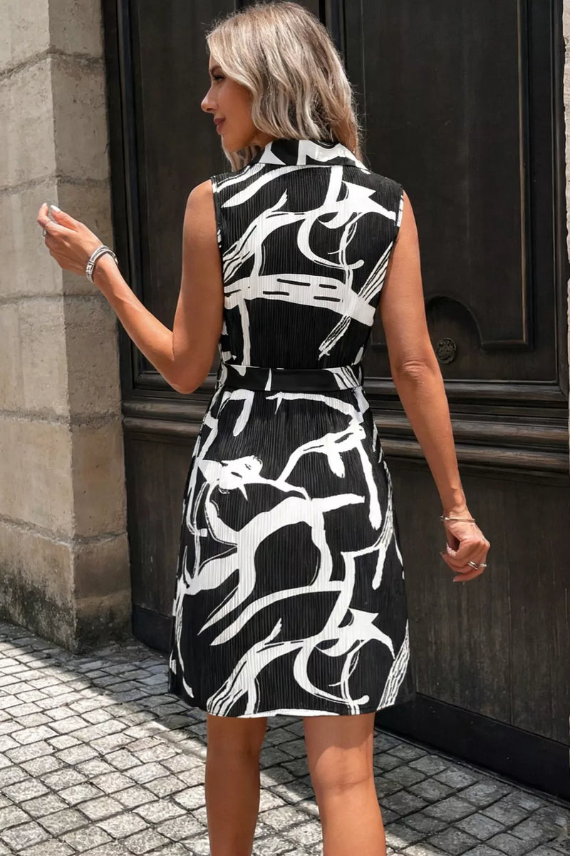Woman wearing a black and white patterned dress standing on a street.