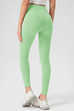Person wearing light green leggings on a white background