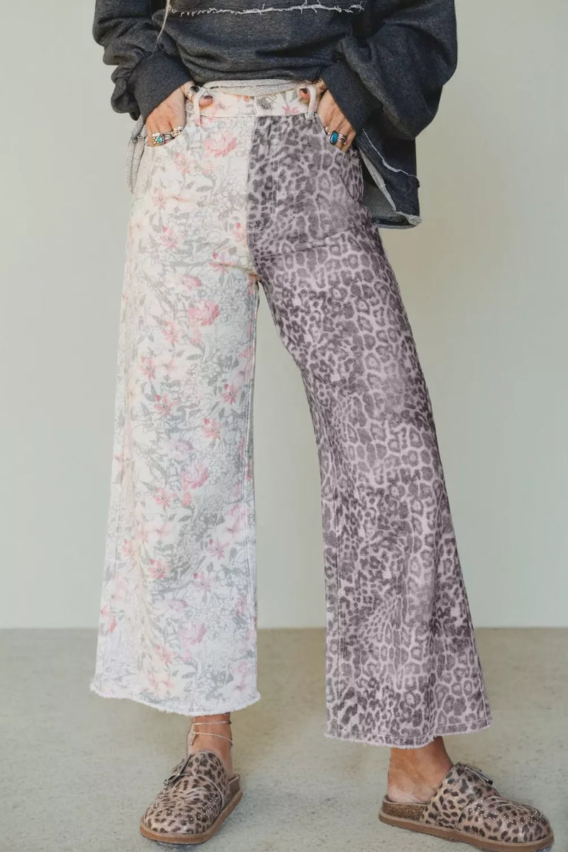 Person wearing a dark jacket, floral pants, and leopard print shoes on a plain background