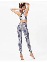 Woman wearing a patterned sports bra and leggings on a white background