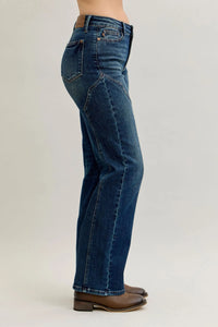 Blue jeans worn by a person on a plain background