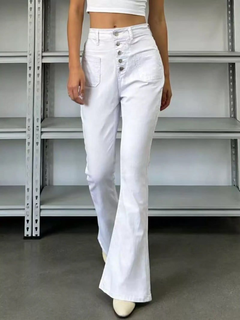 Person wearing white flared jeans in an industrial setting