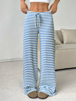 Person wearing blue and white striped pants in a room with a couch.