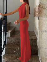Woman in a red dress standing on stone steps with a stone wall background