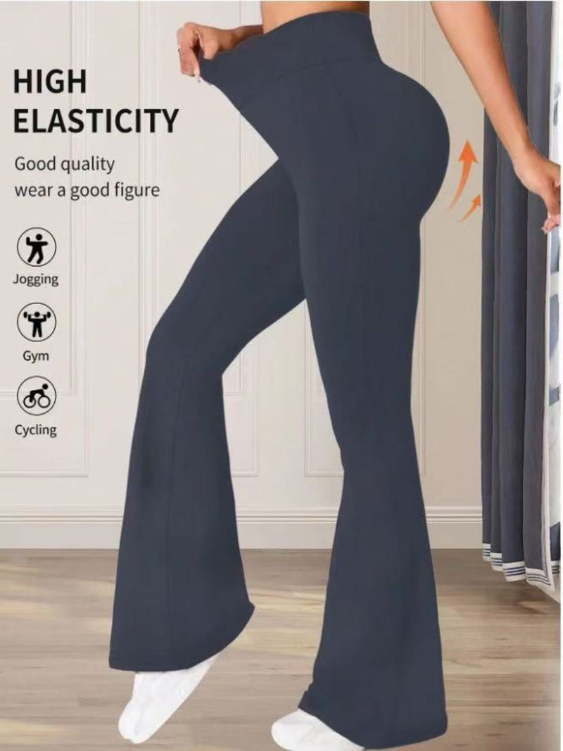 Navy blue flared pants being worn by a person on a wooden floor.