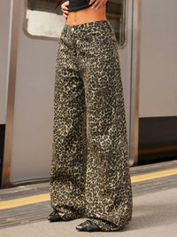 Leopard print pants worn by a person on a train platform.