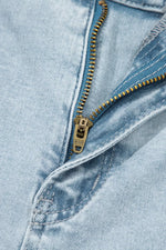 Close-up of a zipper on a pair of light blue jeans